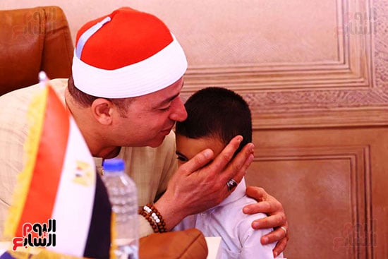 الشيخ طه النعمانى يقبل أحد الأطفال المشاركين بالمسابقة