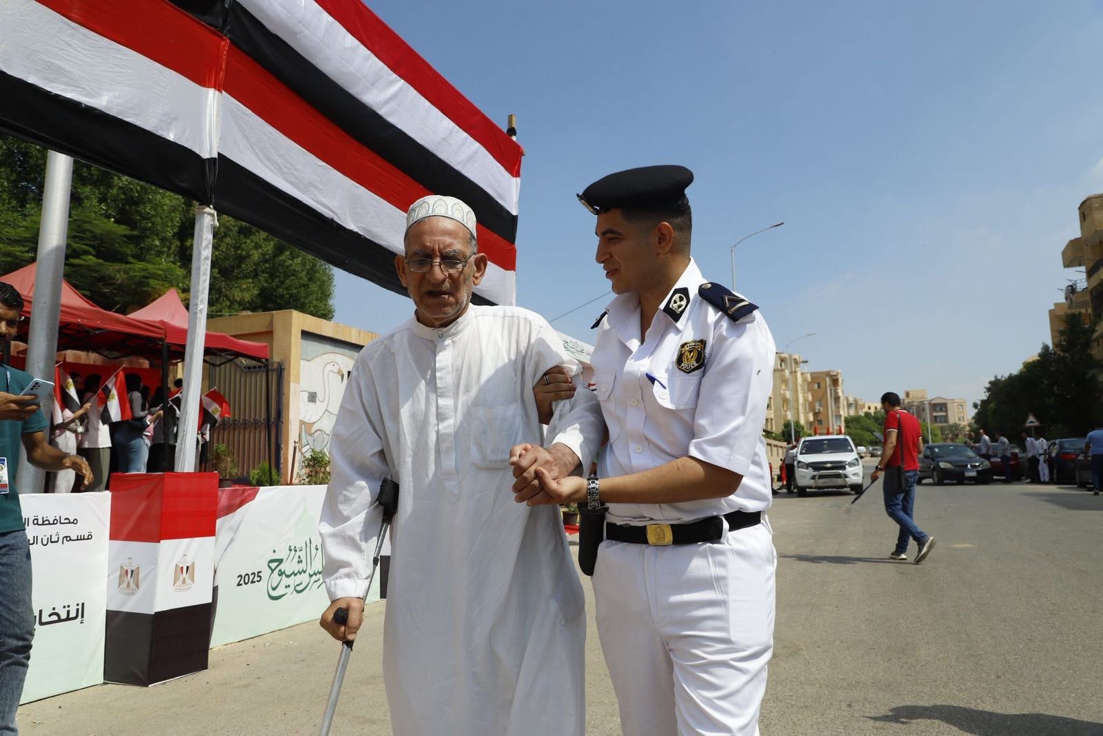 الشرطة تساعد كبار السن أمام لجان التصويت الشرطة تساعد كبار السن أمام لجان التصويت