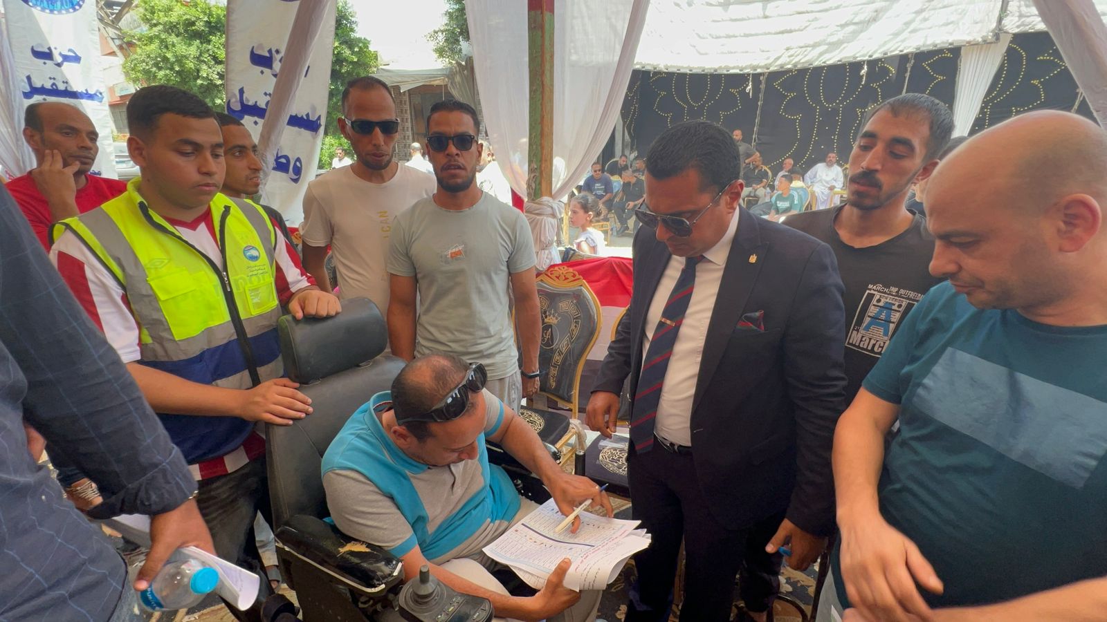 قاضٍ يساعد أحد ذوي الهمم على التصويت في انتخابات الشيوخ (1)