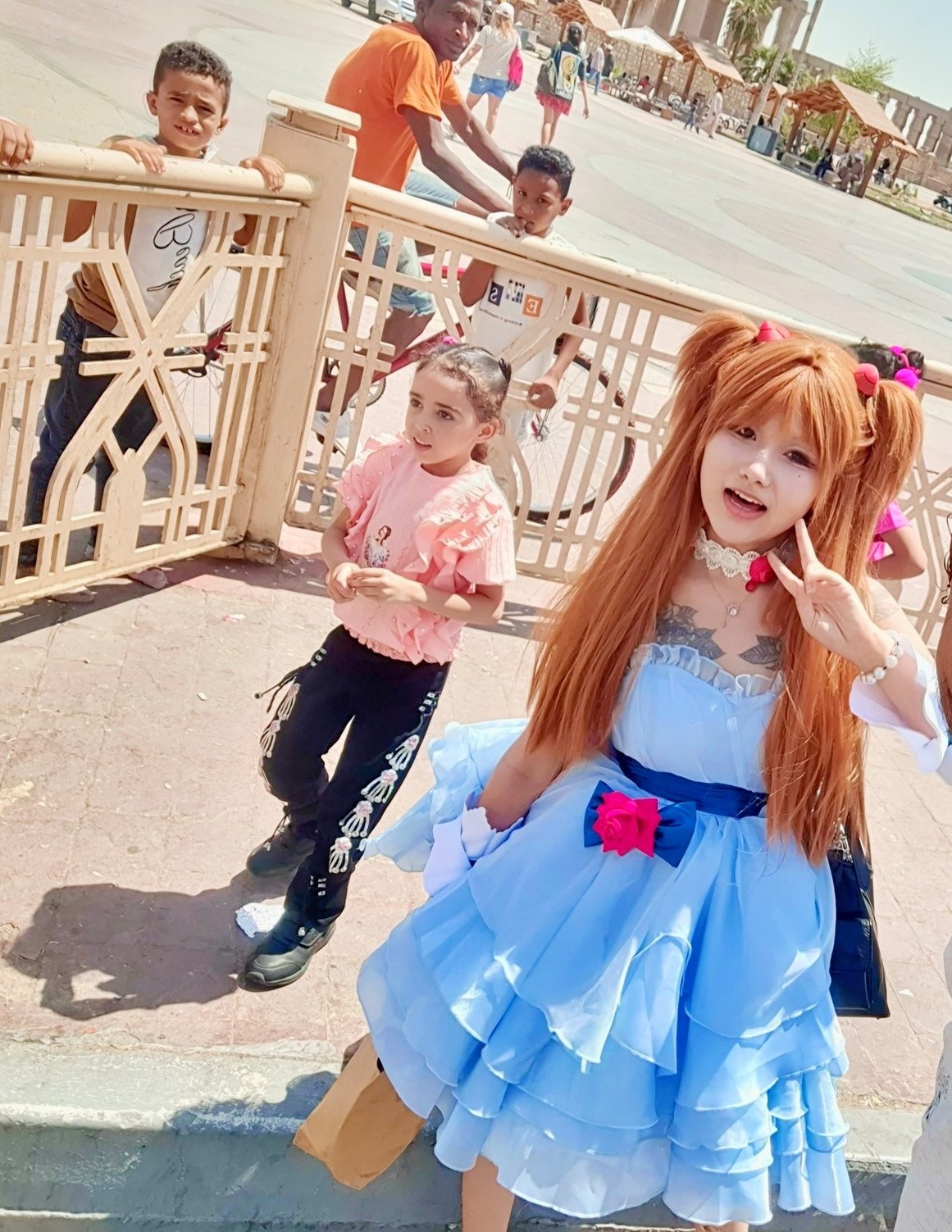 أجنبية تستمتع مع أطفال الأقصر في ساحة أبوالحجاج بزي باربي