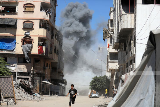 طفل يفر من القصف على المبانى فى مدينة غزة