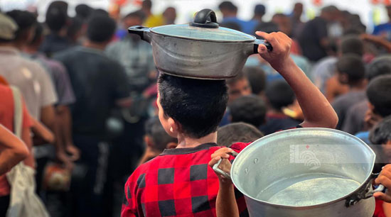 طفل يحمل الأوانى للحصول على الطعام طفل يحمل الأوانى للحصول على الطعام