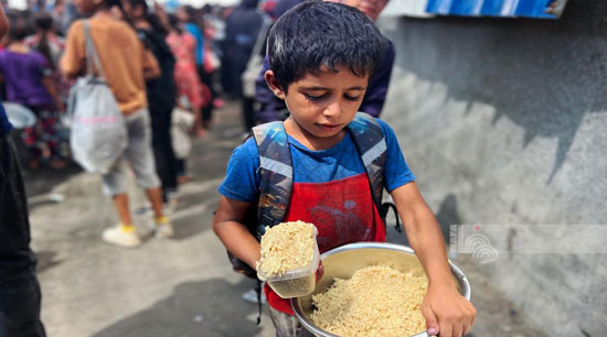 طفل يحمل فى وعاء القليل من الحساء طفل يحمل فى وعاء القليل من الحساء
