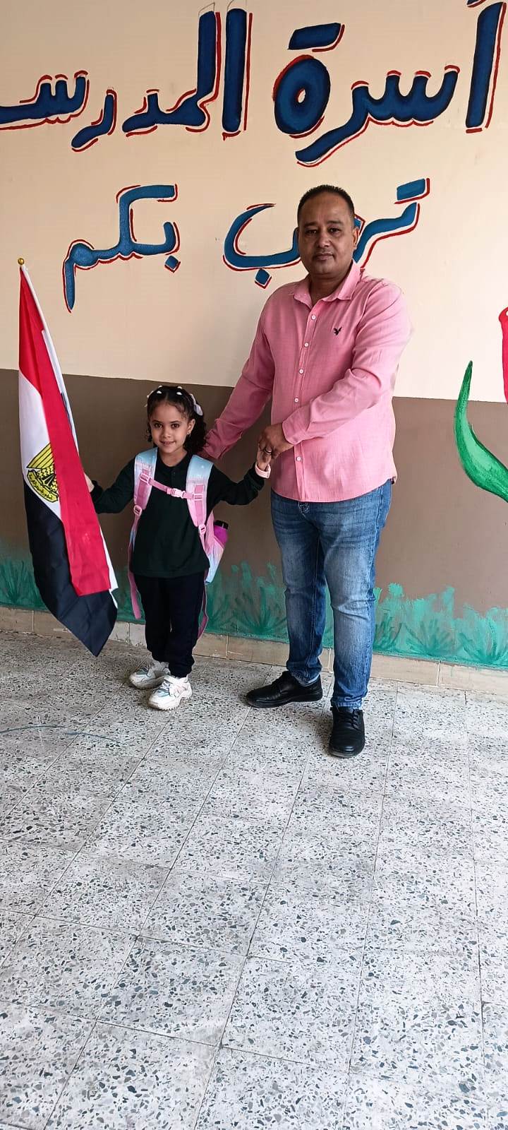 مدير مدرسة الأبطال يستقبل الطلاب بعلم مصر