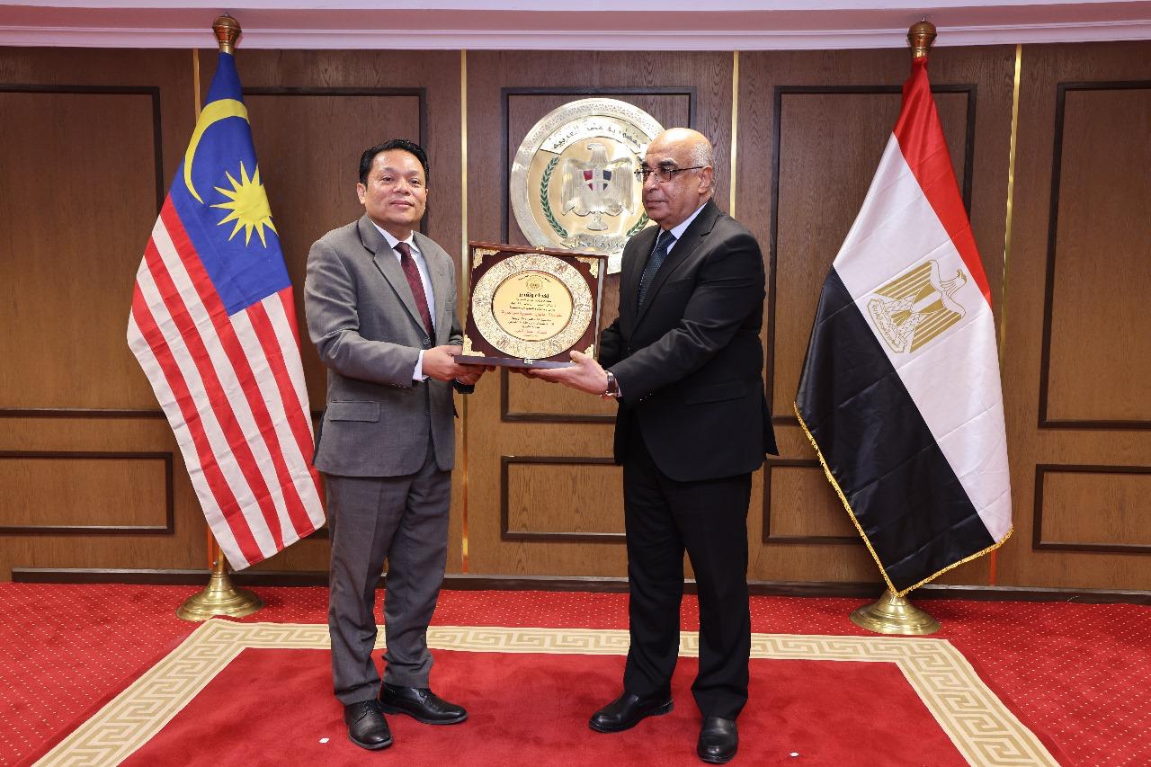 وزير العدل يقدم درع للوفد الماليزي