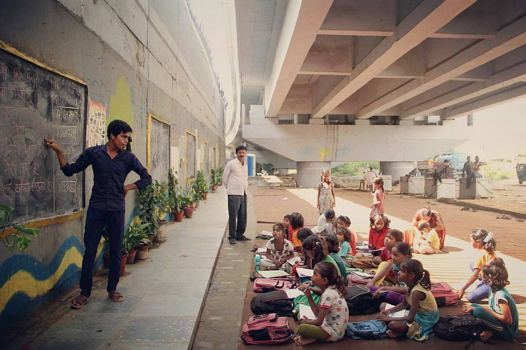 معلم يدرس لطلبة فقراء