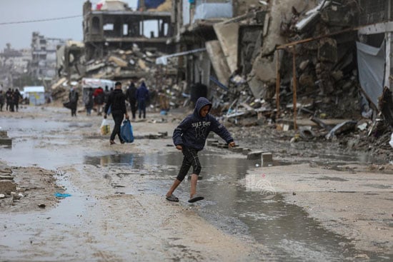 طفل يسير وسط مياه الامطار