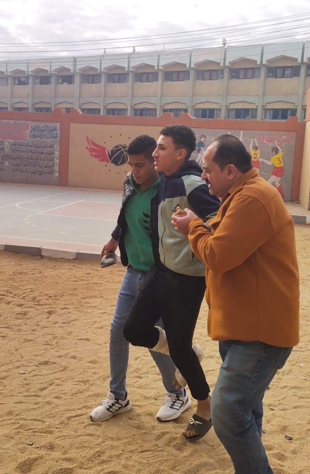 أحد القائمين على الامتحانات يساند الطالب رفقه زميله