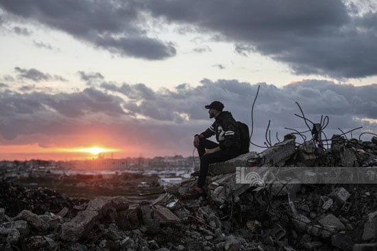 فلسطينى يجلس على ركام المبانى المدمرة