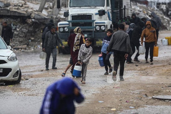 أطفال يحملون مياه للشرب