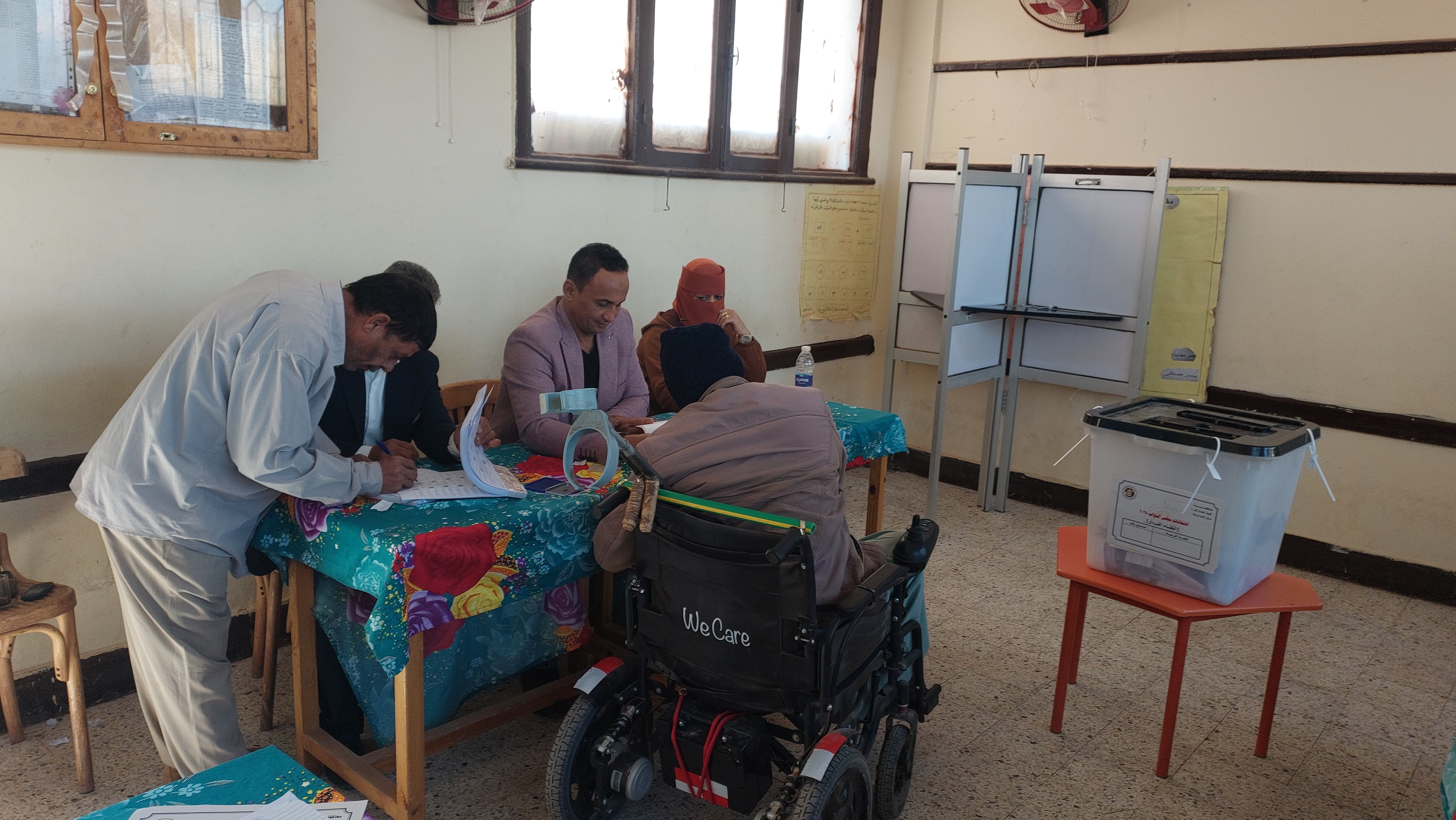 رئيس لجنة انتخابية بمركز بلاط يساعد ناخب على كرسي