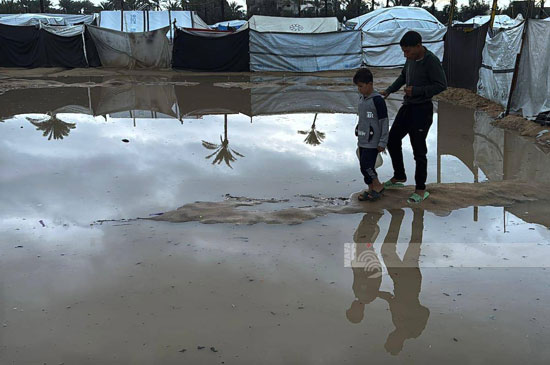 الأطفال يسيرون فى مياه الأمطار والصرف الصحى الأطفال يسيرون فى مياه الأمطار والصرف الصحى