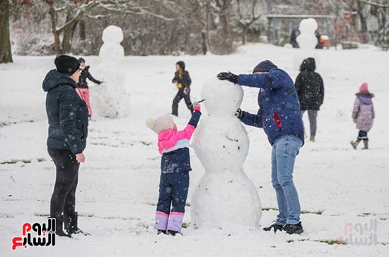 استمتاع العائلات بتساقط الثلج