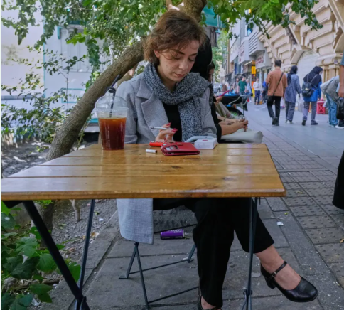 سيدة تجلس فى أحد مقاهى طهران