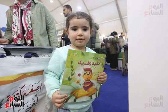 طفلة تمسك قصة