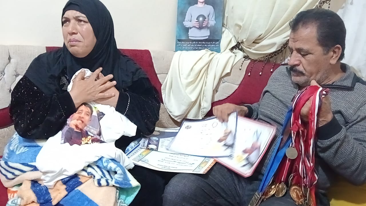 والد الاعب محمد سمك يمسك بميدالياته التي حصل عليها