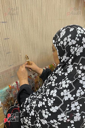 سعاد وهي تصنع قطعة سجاد على النول