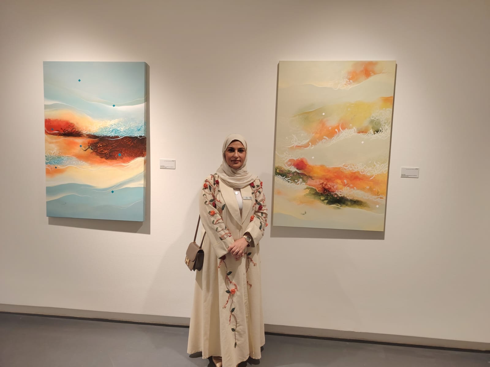 الفنانة فاطمة الحمادى مع عدد من أعمالها بملتقى الخط العربى