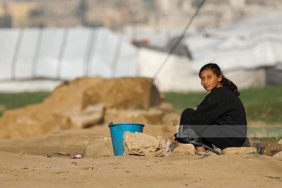 طفلة تجلس للحصول على القليل من المياه طفلة تجلس للحصول على القليل من المياه