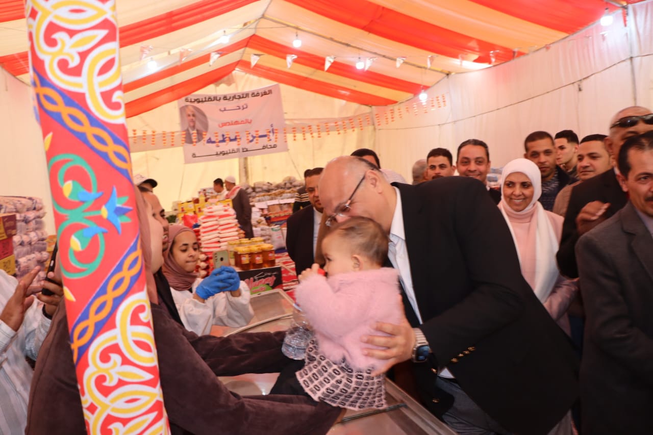 المحافظ يداعب طفلة بالمعرض