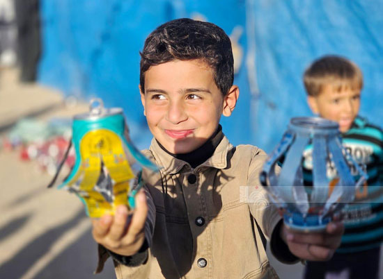 طفل نازح يساعد فى عمل الزينة