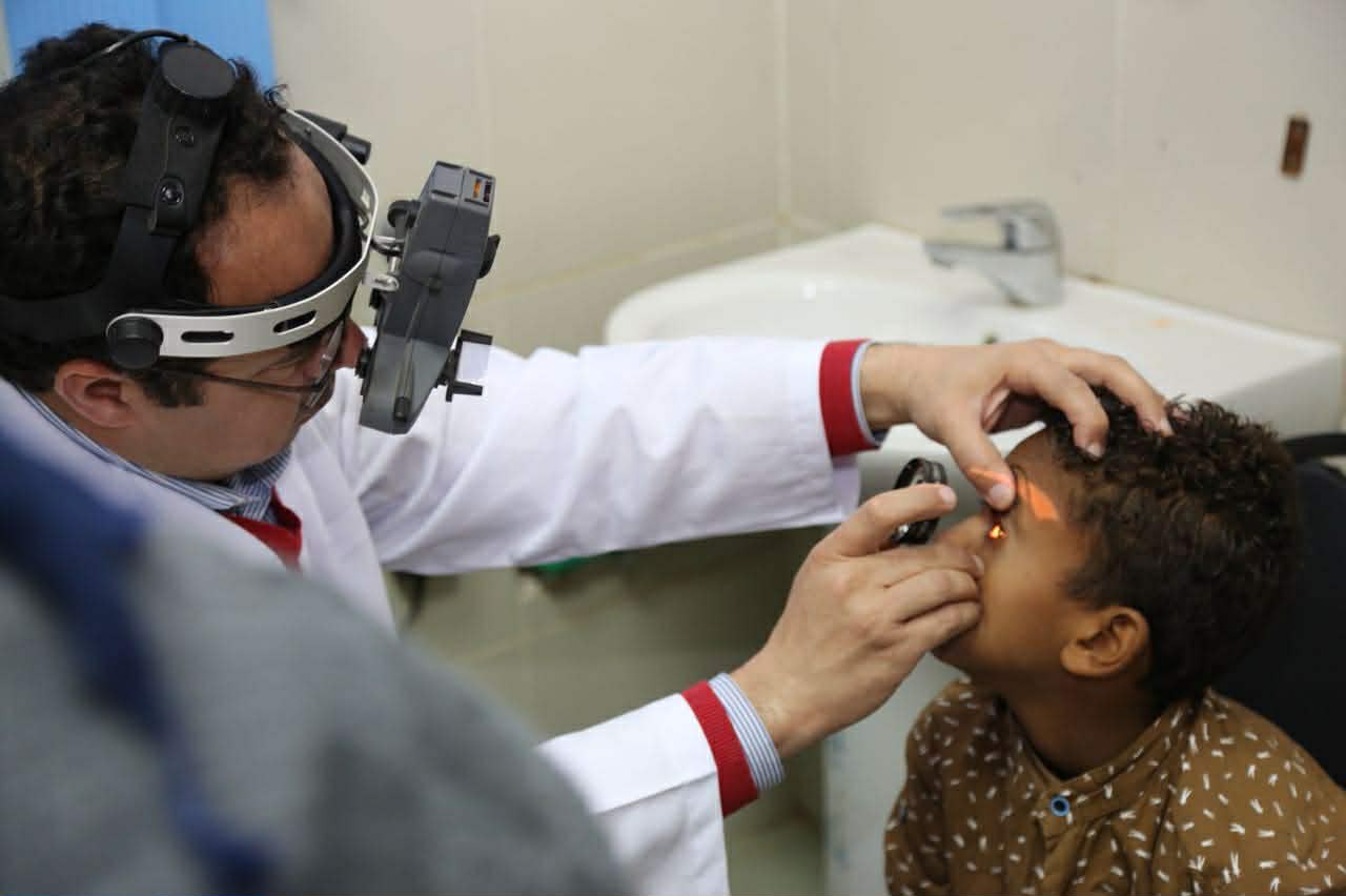 الدكتور شريف دبور يجرى الكشف الطبى على طفل مريض