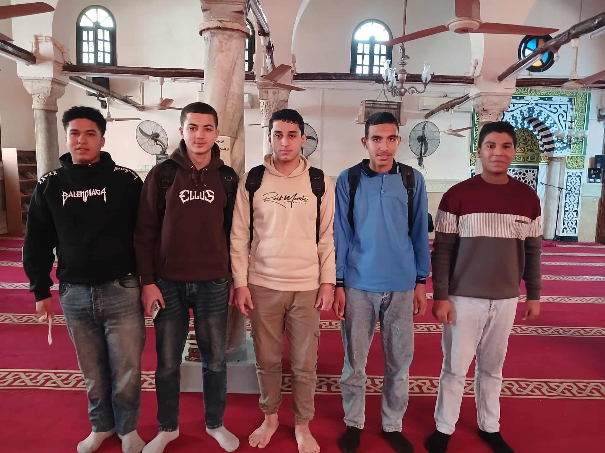 عدد من الطلاب بعد تاديتهم صلاة الظهر فى المسجد