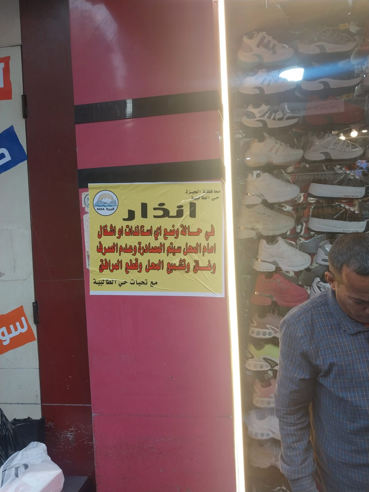 بدء تعليق ملصقات تحذيرية على محلات شارع العريش (2)