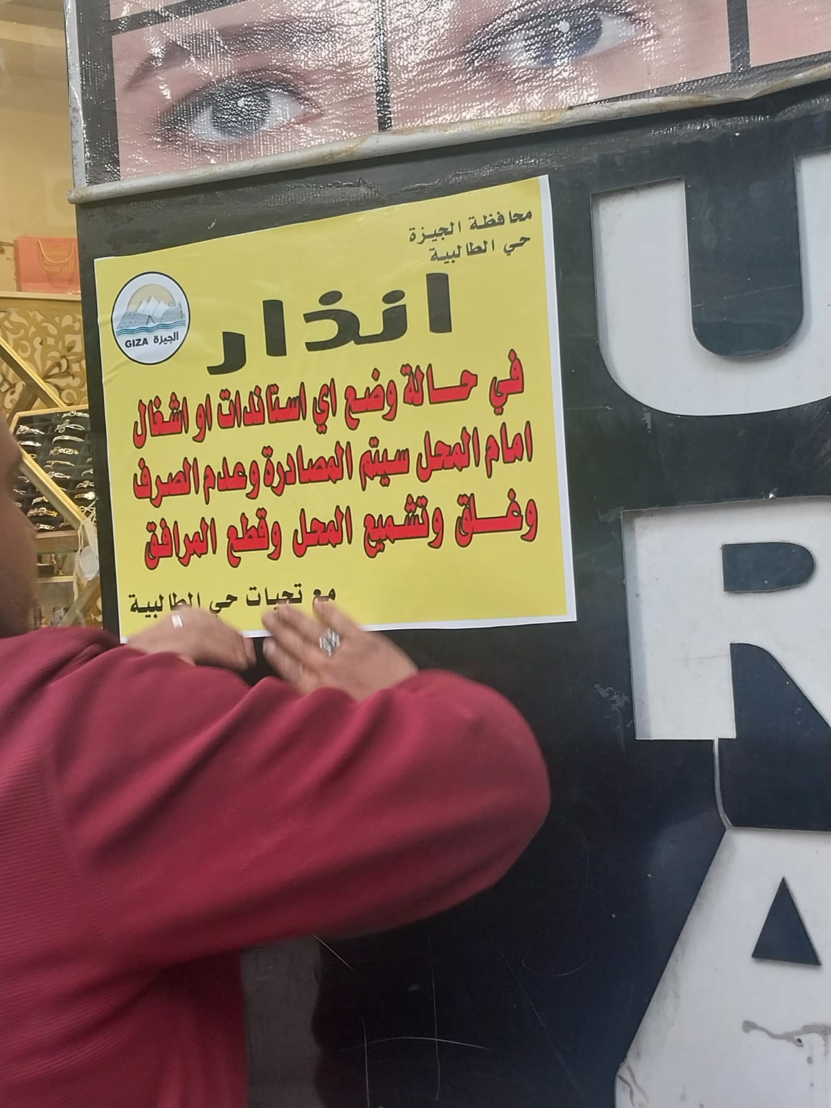 بدء تعليق ملصقات تحذيرية على محلات شارع العريش (3)
