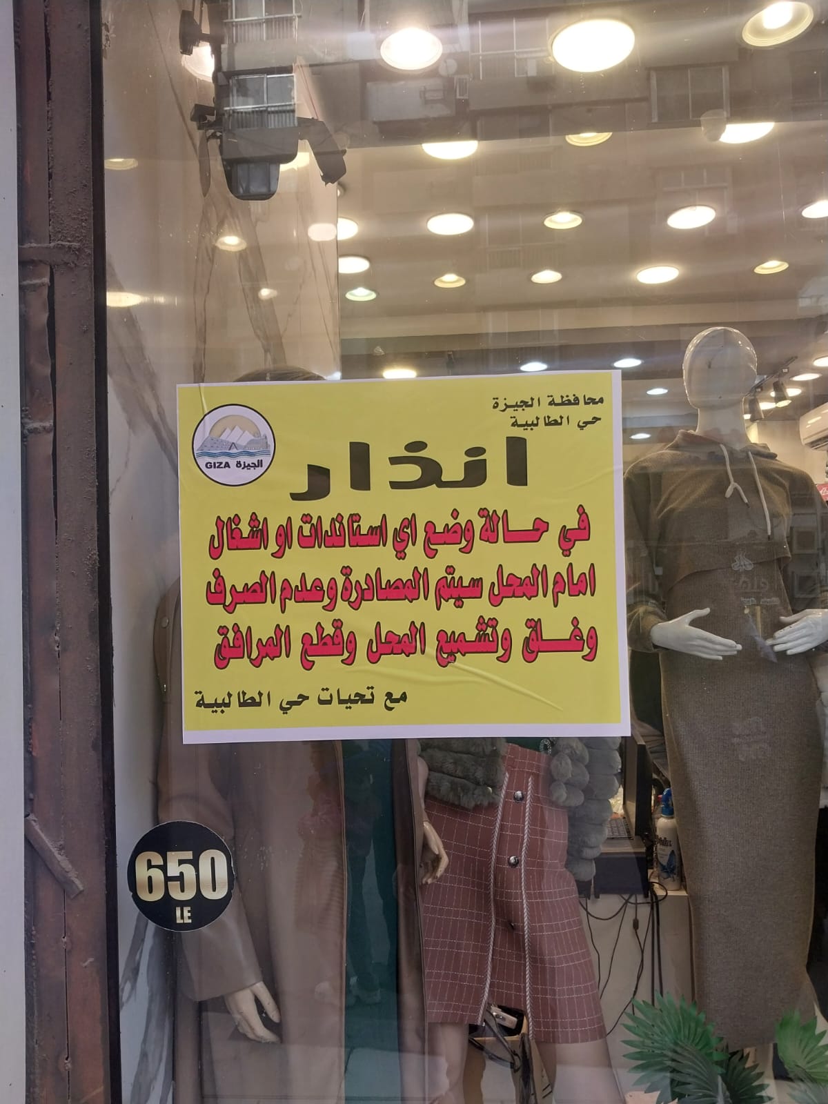 بدء تعليق ملصقات تحذيرية على محلات شارع العريش (1)