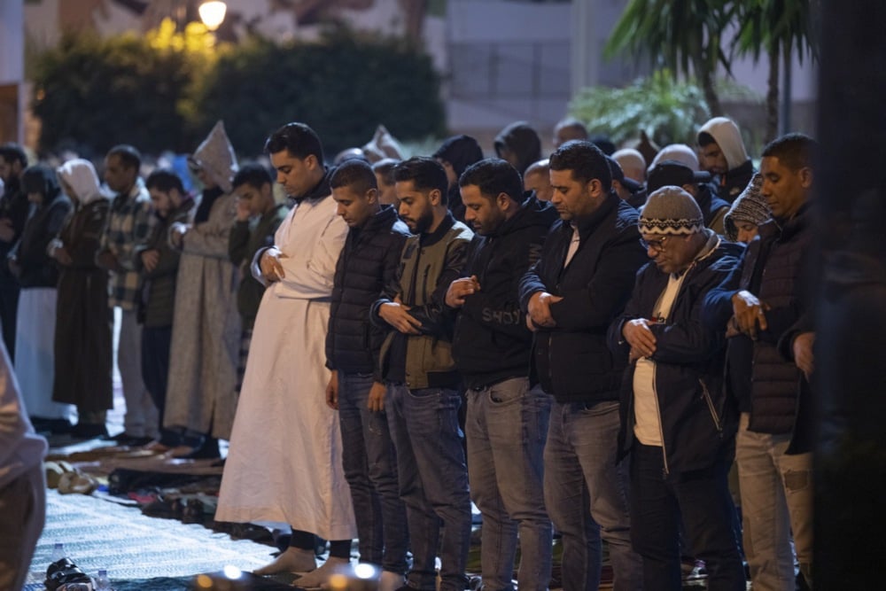 يؤدي مسلمون مغاربة صلاة التراويح في أحد شوارع الرباط، المغرب (5)