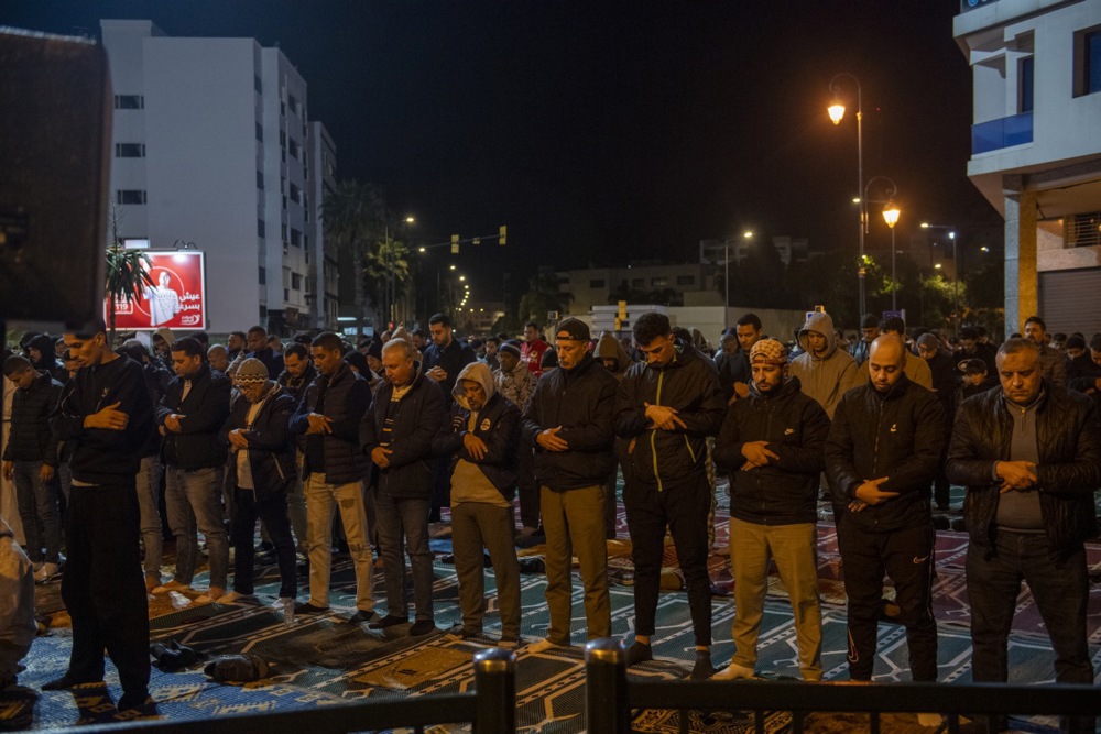 يؤدي مسلمون مغاربة صلاة التراويح في أحد شوارع الرباط، المغرب (4)