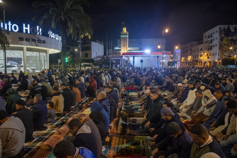 يؤدي مسلمون مغاربة صلاة التراويح في أحد شوارع الرباط، المغرب (3)