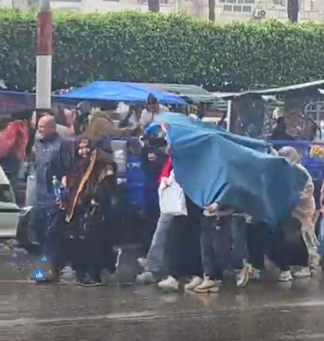 أسر تحتمي بخيمه من الأمطار الغزيرة