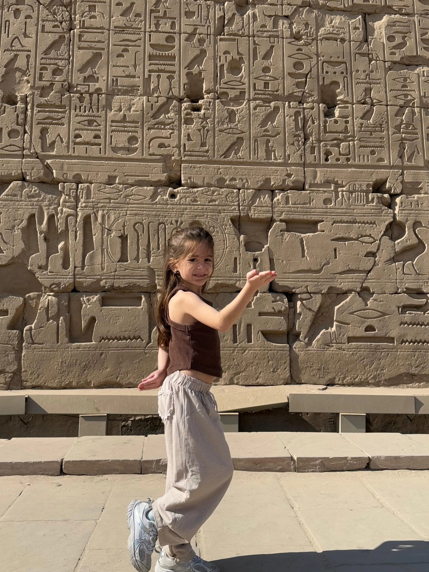 استمتاع طفلة بين جدران معابد الكرنك