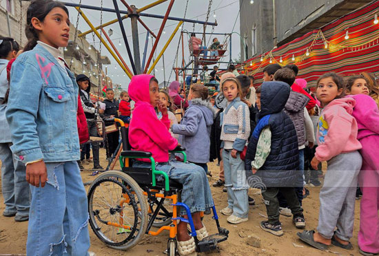 طفل يجلس على كرسى متحرك لمشاهدة المهرجين
