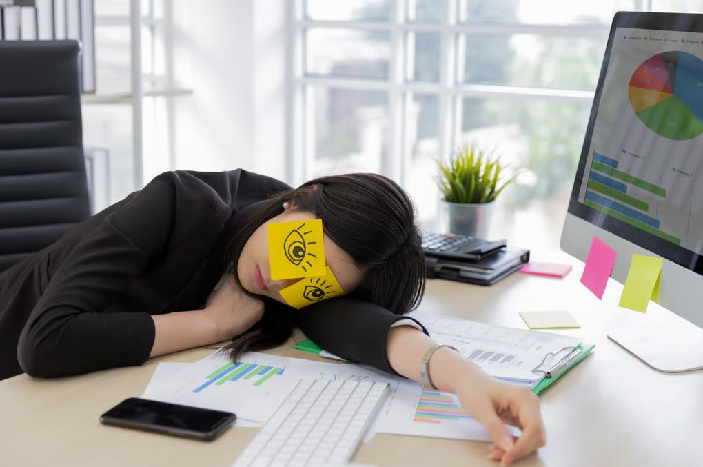 امرأة منهكة تتكئ على مكتبها