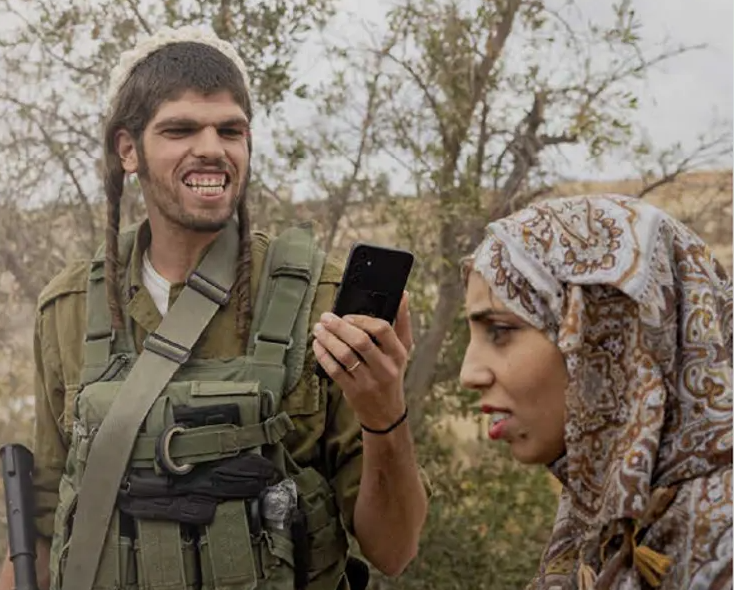 مجند يهودي أمام سيدة فلسطينية