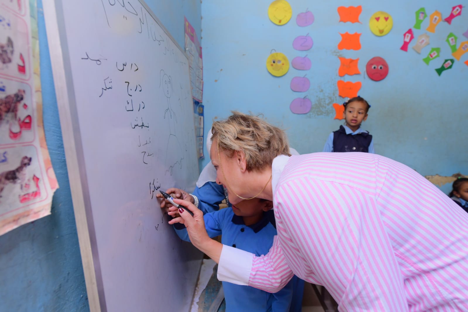 سفيرة الاتحاد الأوروبى تحاول مع طفل الكتابة