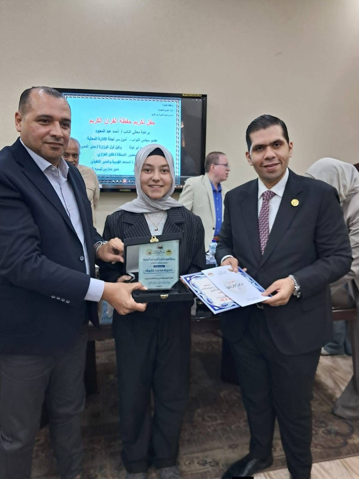 النائب يسلم الطالبة درع التفوق وحفظ القرآن الكريم