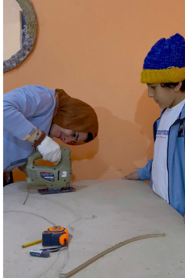 فى الورشة مع طفلها 