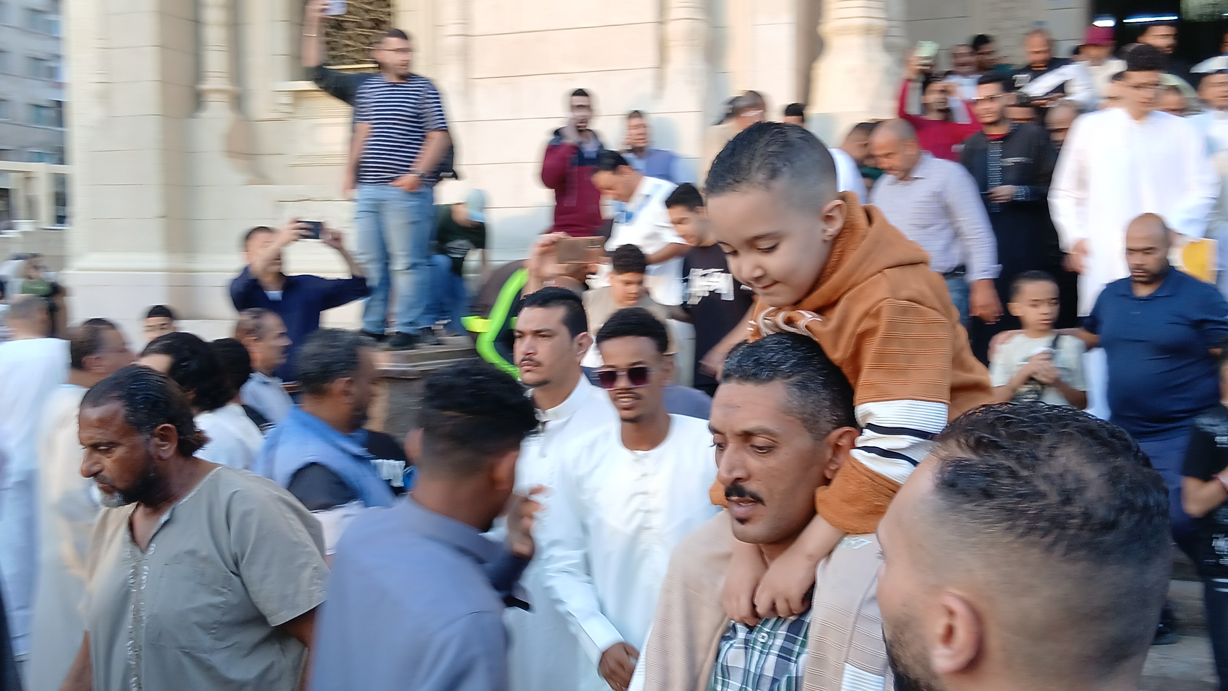اب يحمل ابنه عقب صلاة عيد الأضحى بالإسكندرية