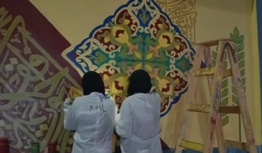طالبات يشاركن في رسم الجداريات