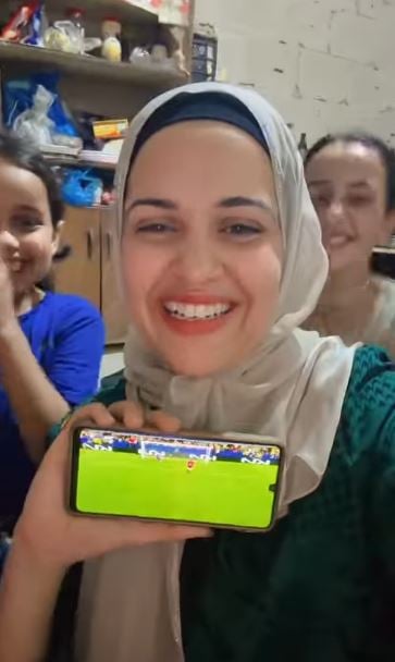 أم فلسطينية تتابع المباراة مع بنتيها