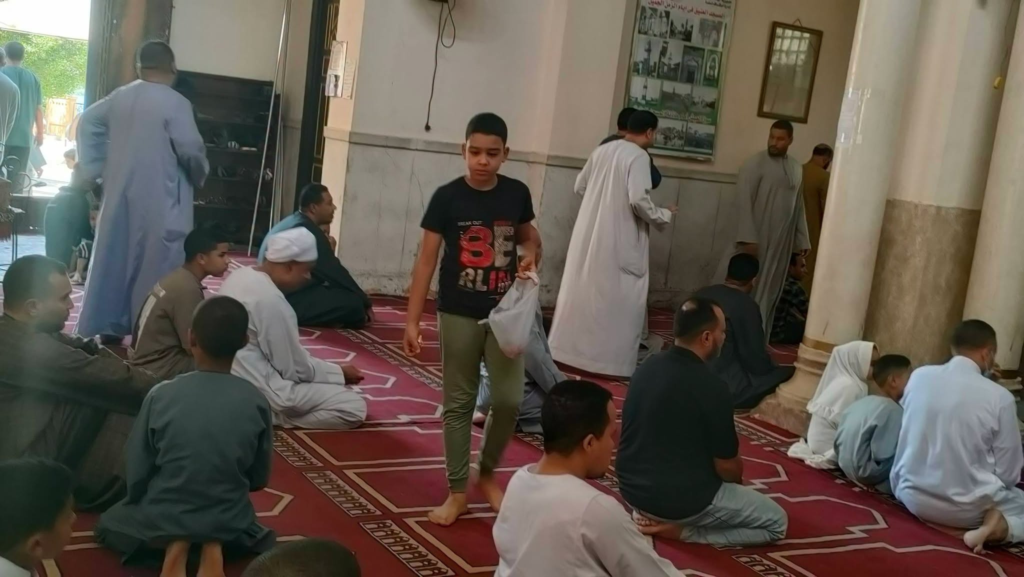 طفل يوزع الحلوى بهجة بقدوم المولد النبوى الشريف في المسجد العتيق