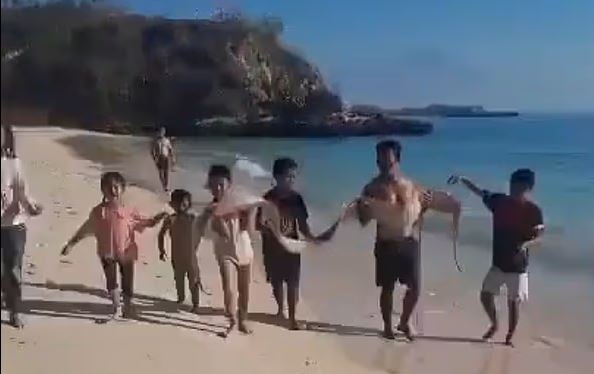 الاطفال يحملون سمكة المجداف
