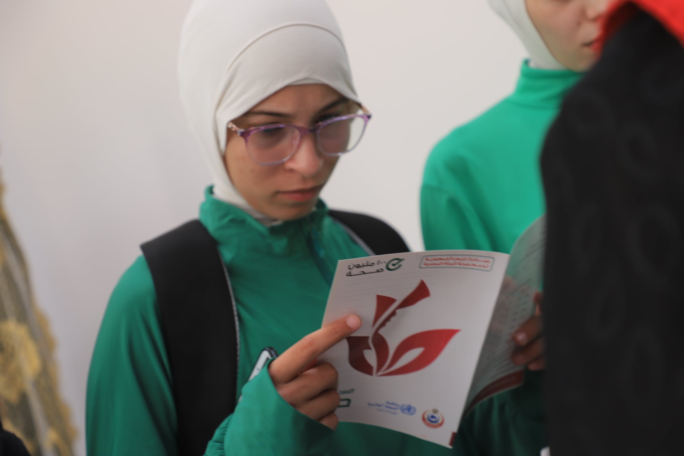 طالبة وكتيب حول ١٠٠ مليون صحة