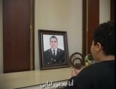 نجل الشهيد رامي هلال أمام صورة والده الراحل