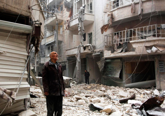 رجل يقف أمام المنازل المنهارة فى حلب
