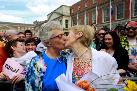 عجوزتان يقبلان بعضهم البعض بعد الموافقة على زواج المثليين